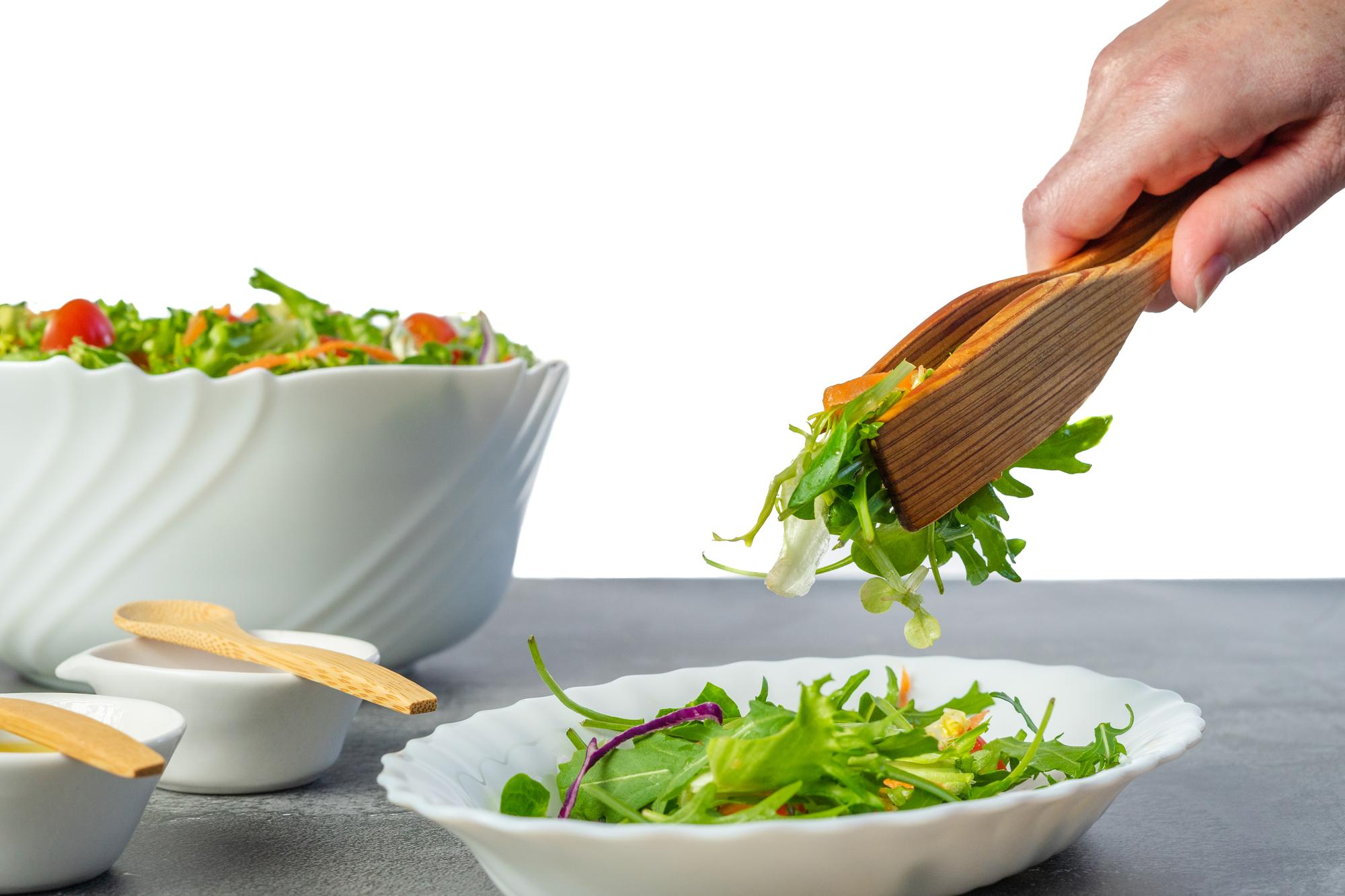 hands plating a composed salad quickly